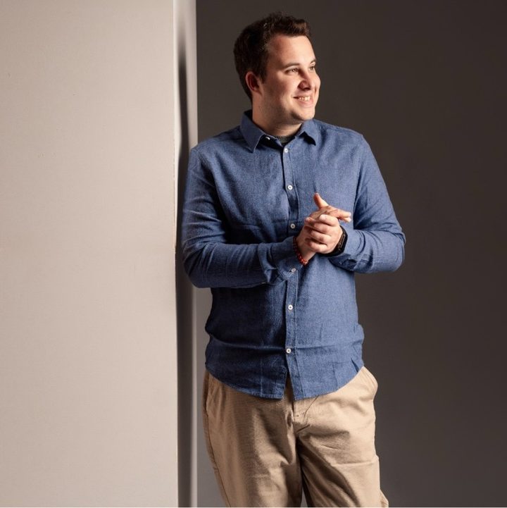 Portrait de Sandro Payfa, souriant, en chemise bleue